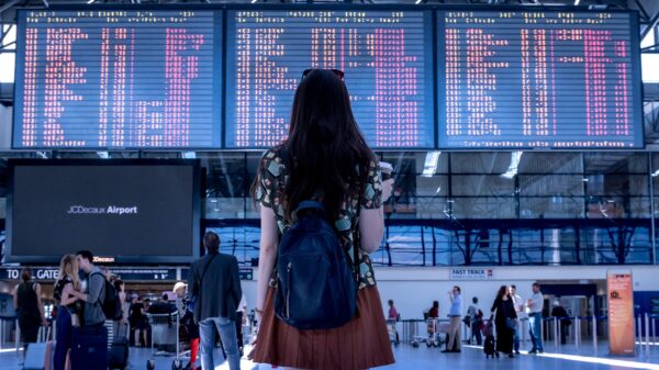 A woman at the airport looking up at the arrivals/departures board