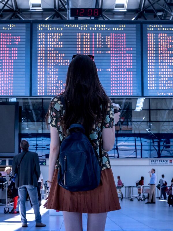 A woman at the airport looking up at the arrivals/departures board