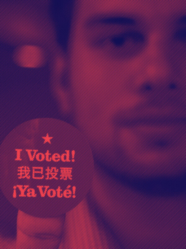 Man holding up a round sticker with text that reads: I voted!