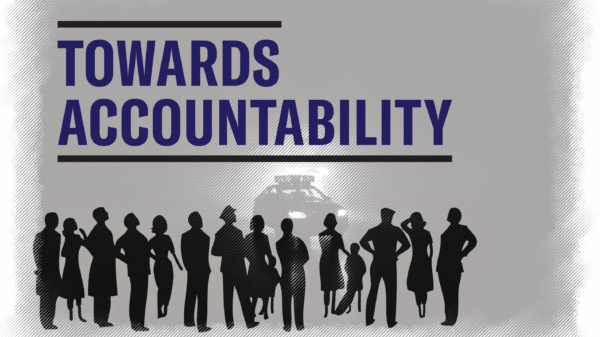 silhouette of people, including police officers in the foreground, a police car with lights in the background