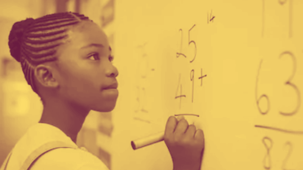 A young Black girl holding a marker, doing arithmetic at a white board