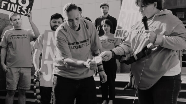 People setting fire to a bill at a protest against criminal system fees