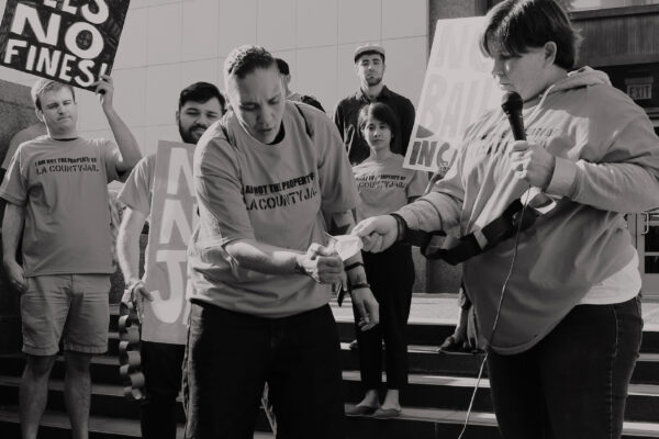 People setting fire to a bill at a protest against criminal system fees