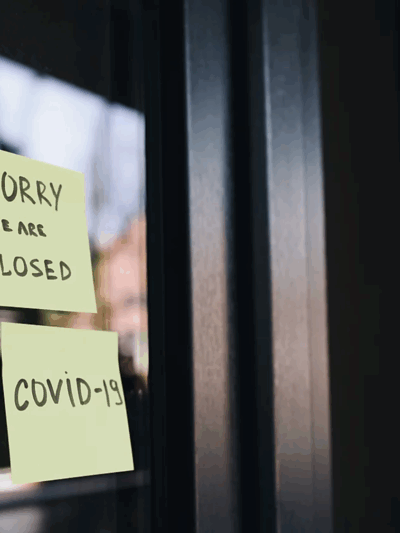 Two post-it notes on a window, the first reads: Sorry we are closed, the second reads: COVID-19
