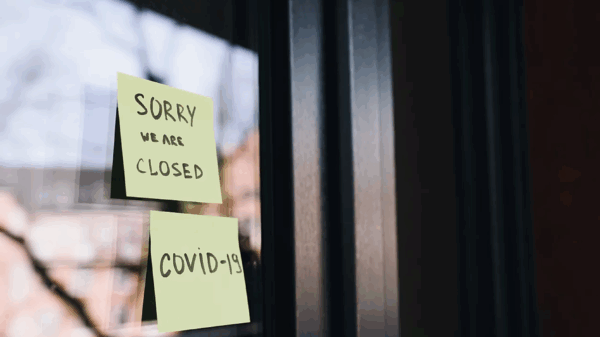 Two post-it notes on a window, the first reads: Sorry we are closed, the second reads: COVID-19