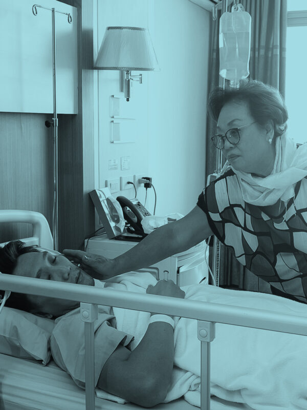 A woman at the hospital bedside of a man