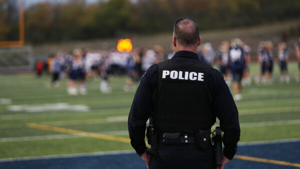 School police overlooking students at football practice