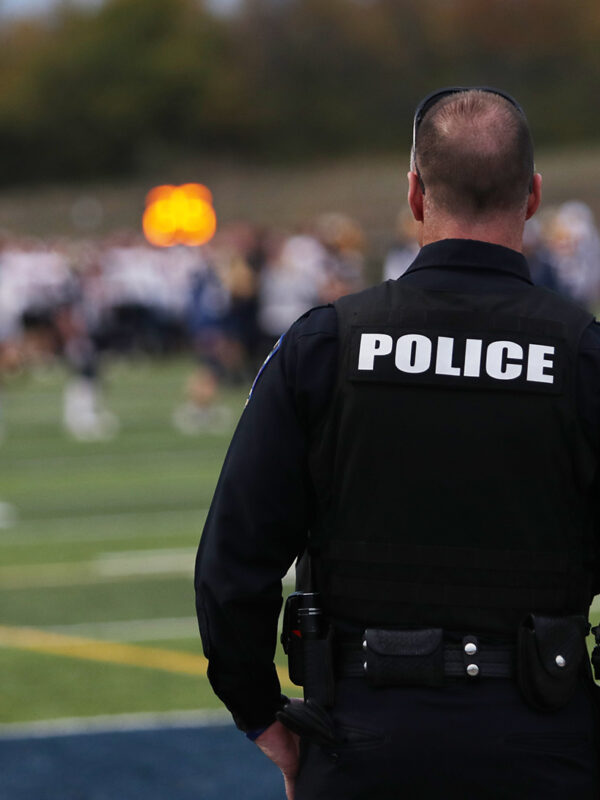 School police overlooking students at football practice