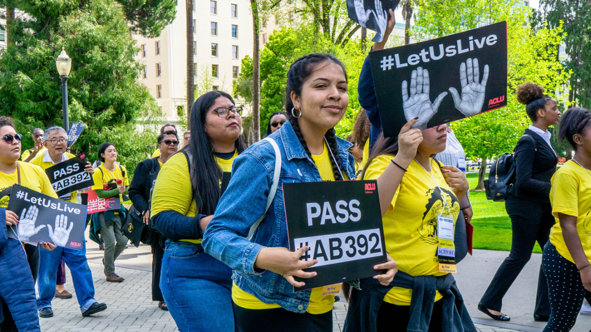 A group of young people wearing matching yellow shirts holding posters in favor of AB 392. They are marching to the California state Capitol.