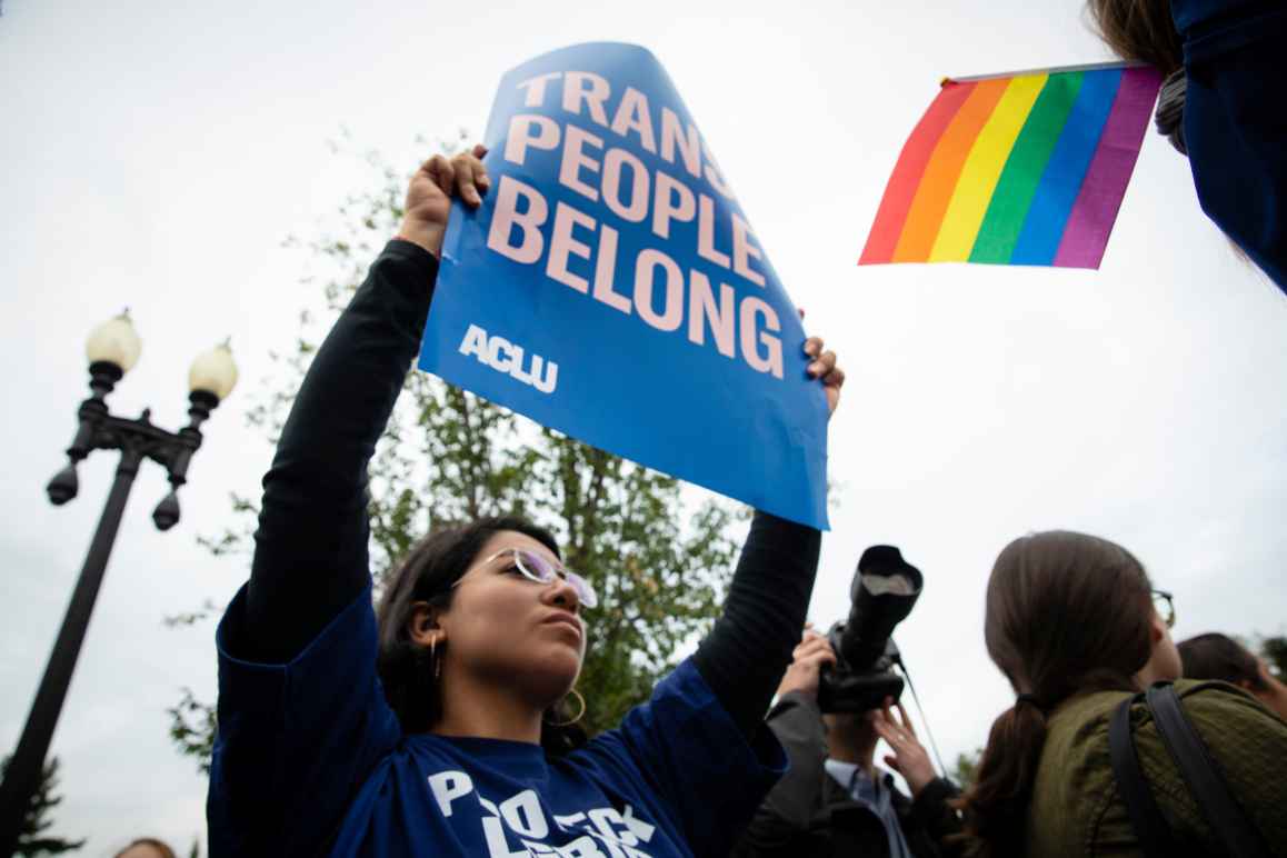 A young woman holding a poster that reads "Trans people belong." Copyright ACLU/Molly Kaplan