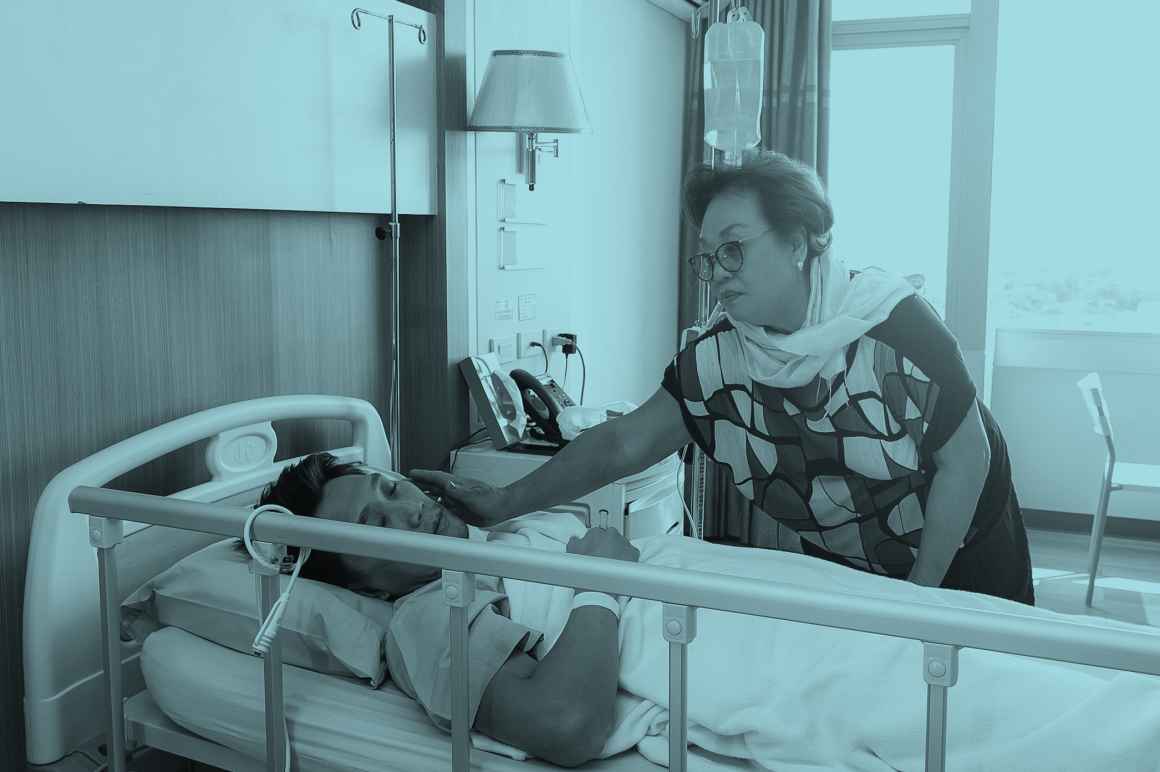 A woman at the hospital bedside of a man