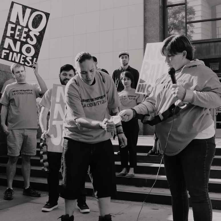 People setting fire to a bill at a protest against criminal system fees