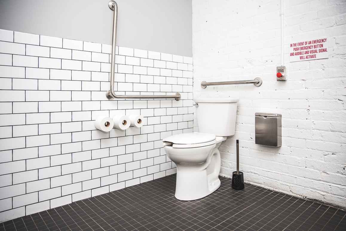 restroom stall with a toilet, toilet paper, grab bar