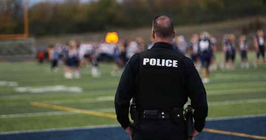 School police overlooking students at football practice