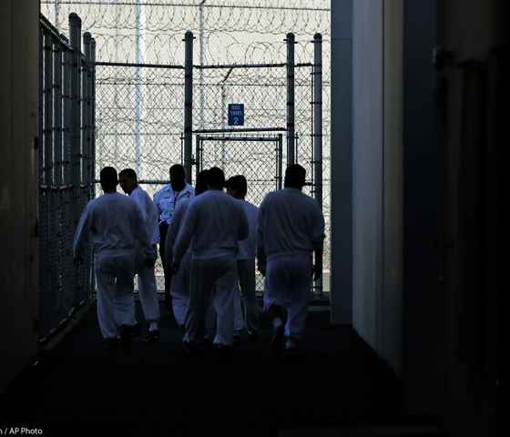 Detainees walk toward a fenced recreation area inside of an ICE detention facility in Washington state.